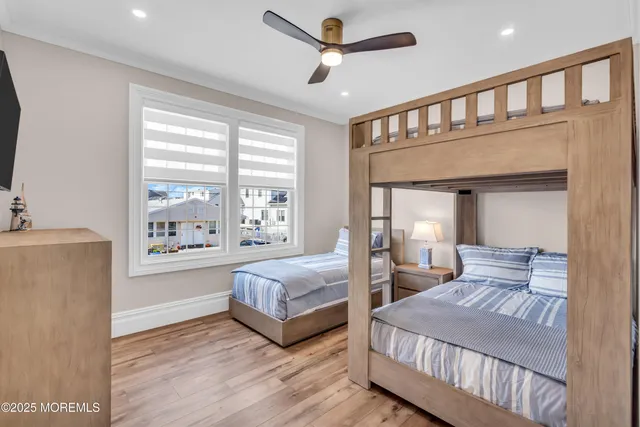 a bedroom with two beds and a ceiling fan