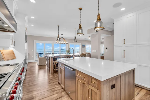 a kitchen with white cabinets stainless steel appliances and wooden floor