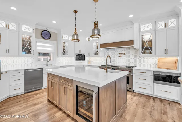a kitchen with kitchen island granite countertop a sink a stove and a wooden floors