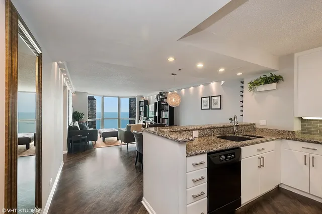 a kitchen with a granite countertop sink and refrigerator
