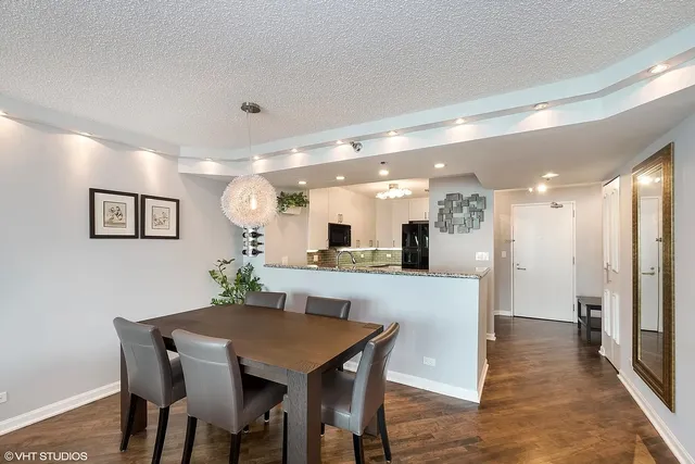 a dining hall with stainless steel appliances kitchen island a table and chairs