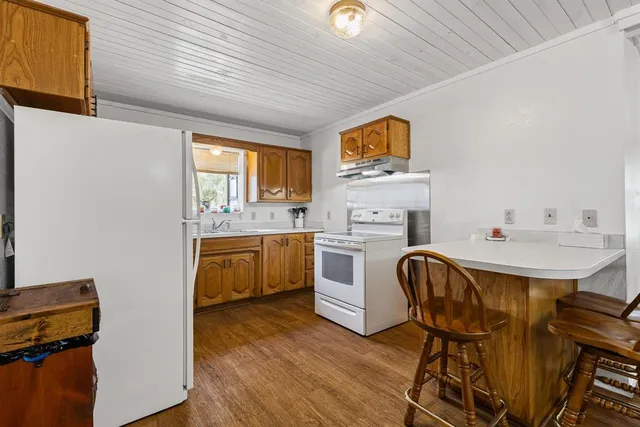 a kitchen with stainless steel appliances granite countertop a sink window and cabinets