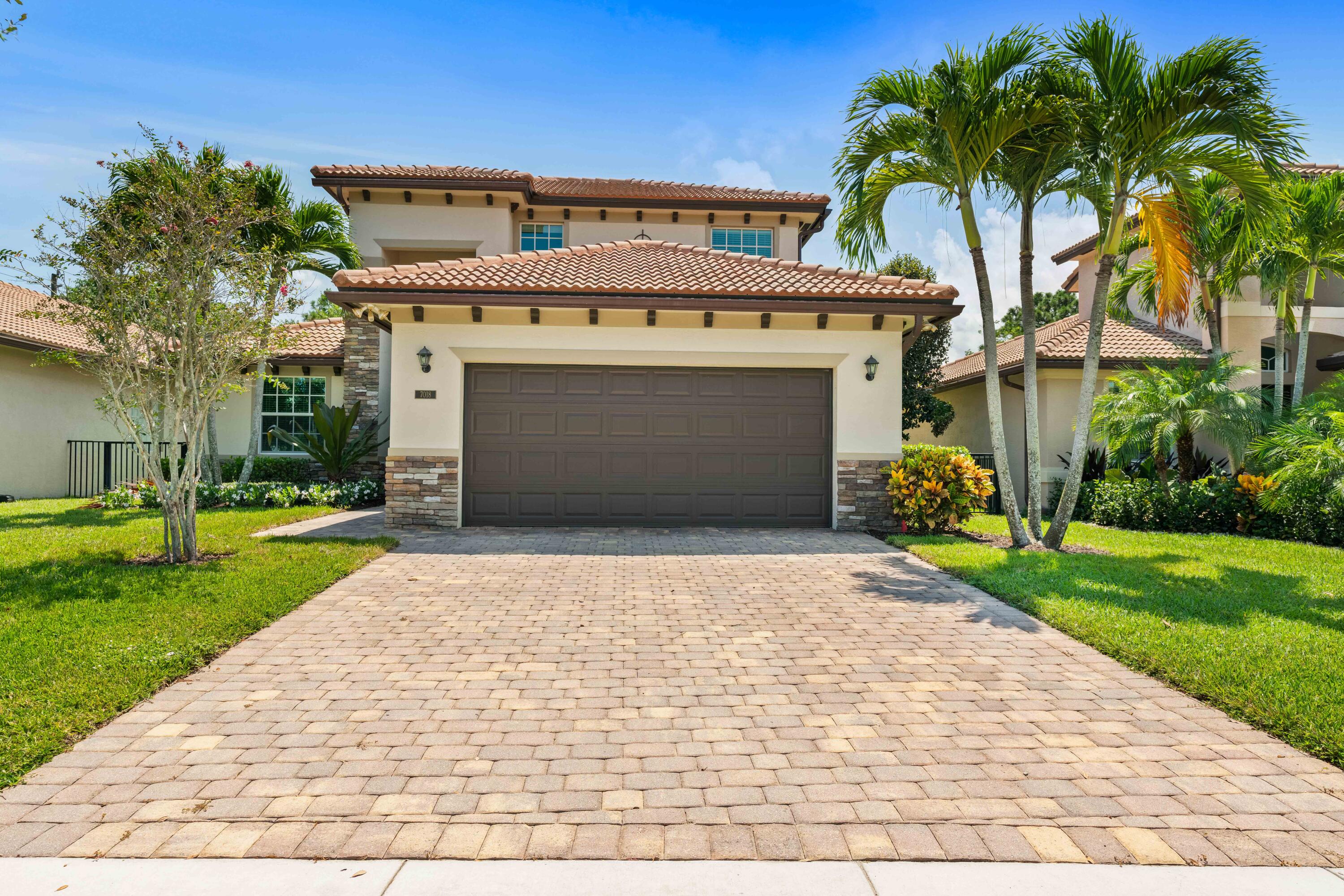 7018 Limestone Cay Road Jupiter, FL 33458 - Photo 22 of 23 a front view of a house with a yard and garage