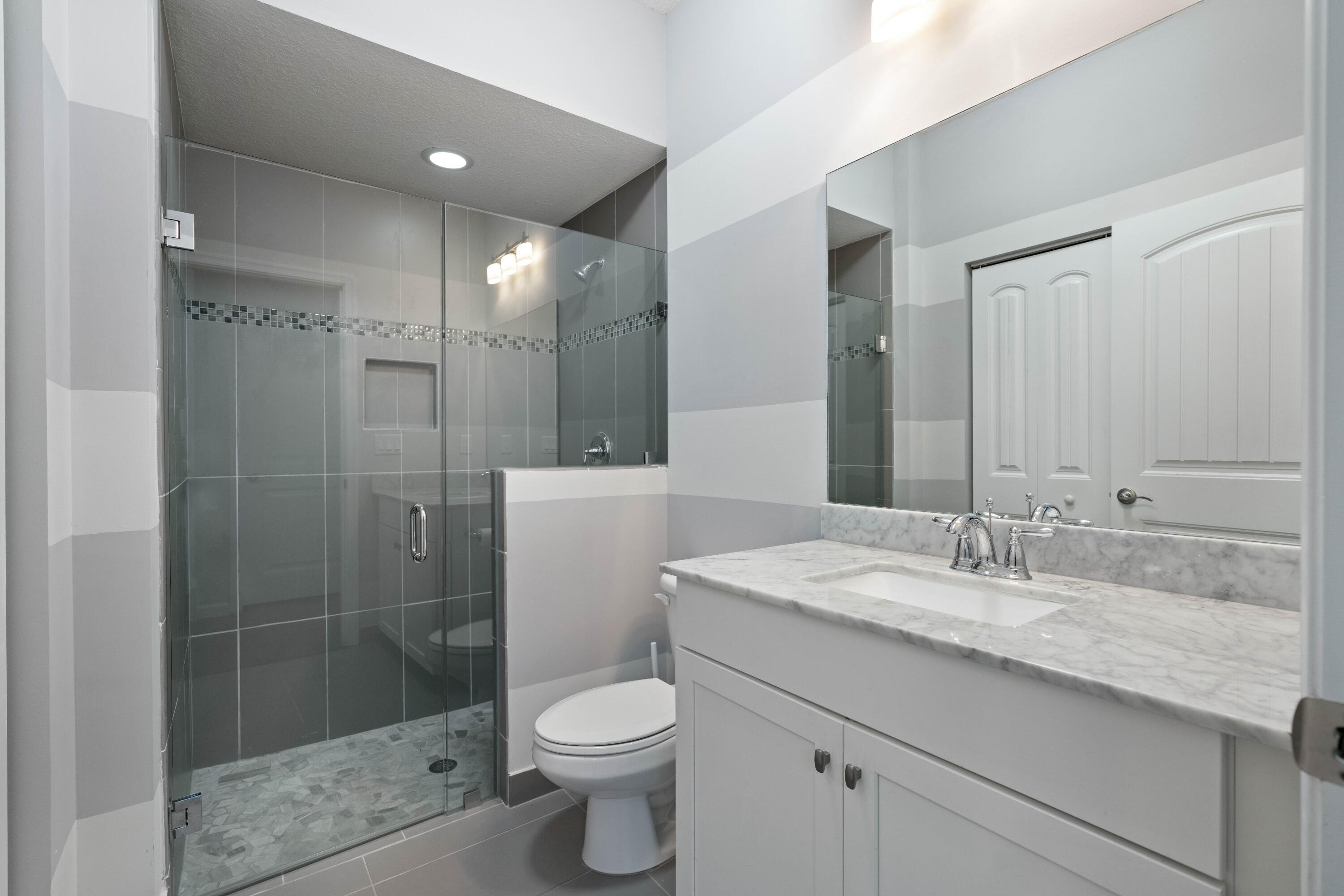 7018 Limestone Cay Road Jupiter, FL 33458 - Photo 9 of 23 a bathroom with a granite countertop sink a toilet and shower