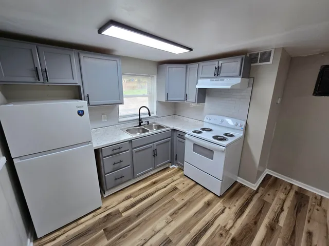 a kitchen with a white stove top oven and sink