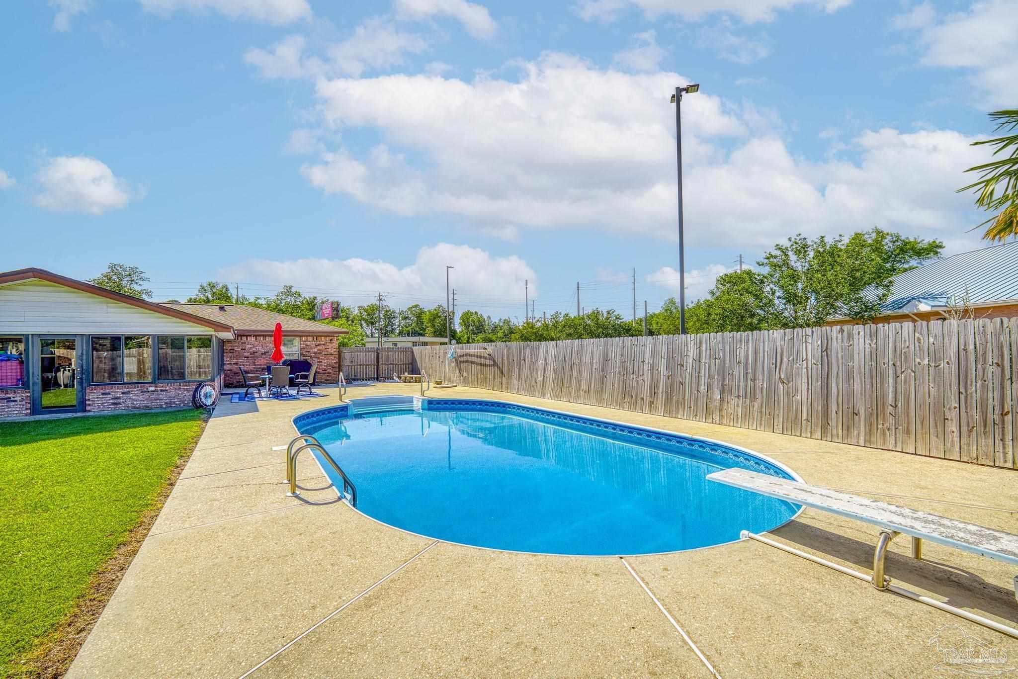 a view of swimming pool with outdoor seating and yard in back