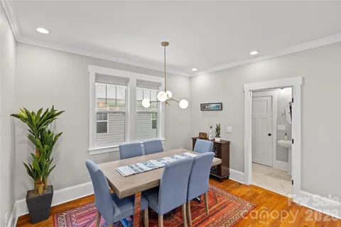 a dining room with furniture potted plants and wooden floor