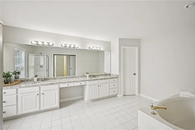 a bathroom with a granite countertop sink a toilet a mirror and shower