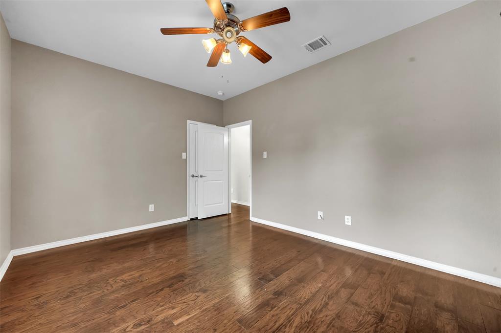 3305 Silver Springs Way Rowlett, TX 75089 - Photo 12 of 40 an empty room with wooden floor and a ceiling fan