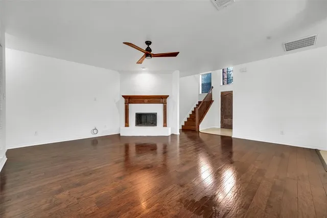 a view of empty room with wooden floor and fireplace