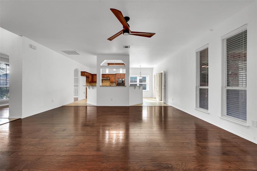3305 Silver Springs Way Rowlett, TX 75089 - Photo 16 of 40 a view of a livingroom with wooden floor and a ceiling fan
