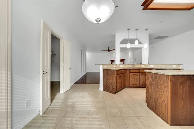 a large kitchen with stainless steel appliances a sink and cabinets
