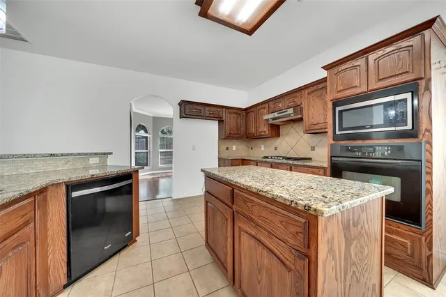 a kitchen with stainless steel appliances granite countertop a stove and a refrigerator