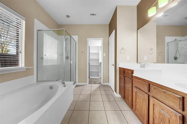 a bathroom with a bathtub a shower a sink and a large mirror