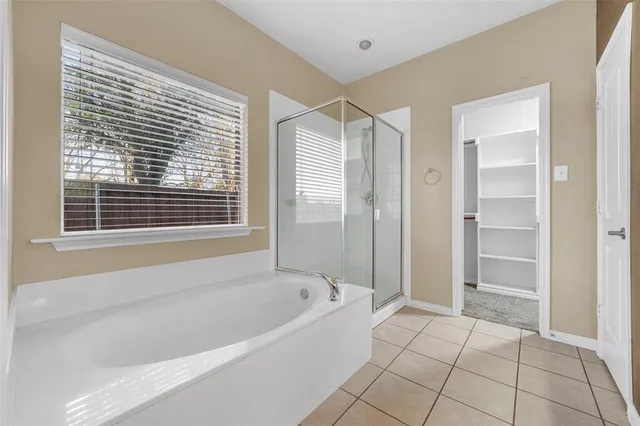 a spacious bathroom with a bathtub and a shower