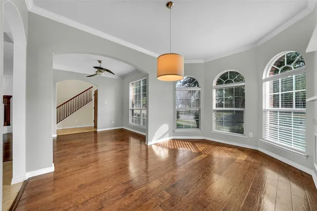a view of an empty room with window and wooden floor