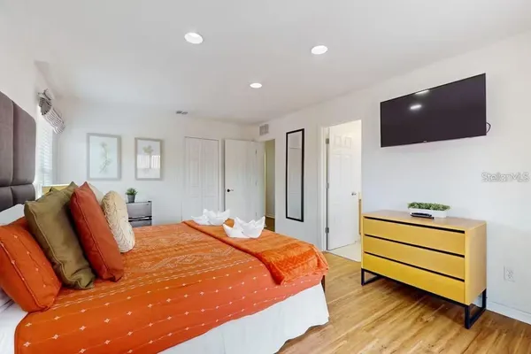 a bedroom with a bed and a flat screen tv