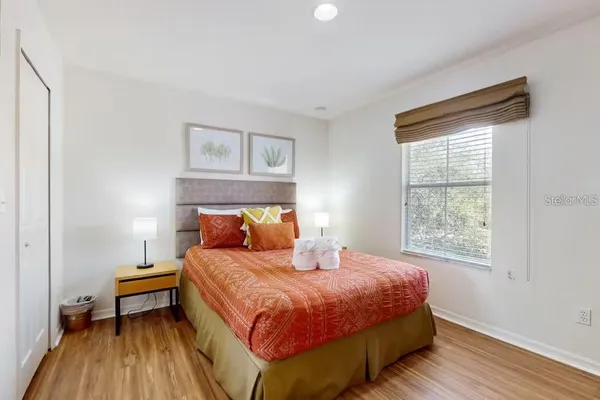 a bedroom with a bed and wooden floor