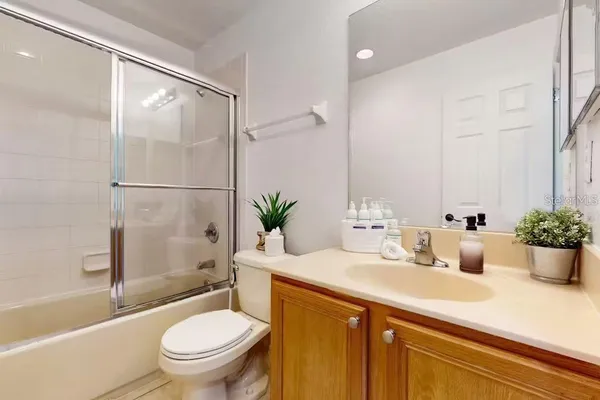 a bathroom with a sink a toilet a tub and shower