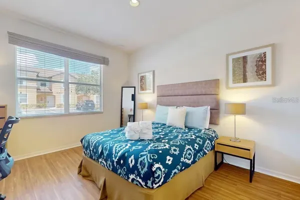 a bedroom with a bed and wooden floor