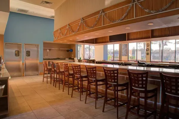 a dining hall with stainless steel appliances a dining table chairs and granite counter tops