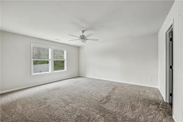 an empty room with a window and a ceiling fan