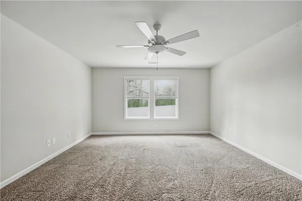 an empty room with fan and windows