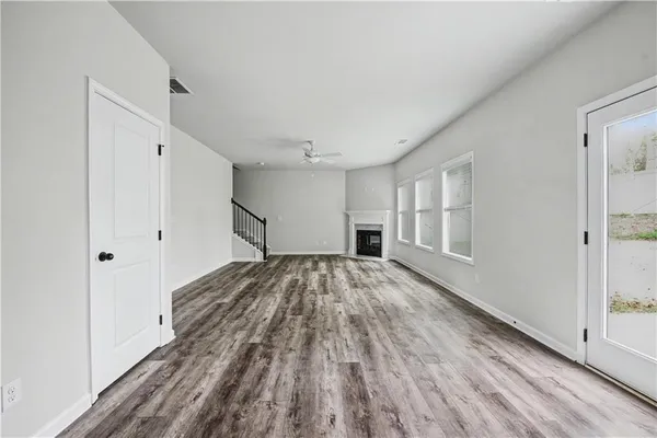 a view of empty room with wooden floor and window
