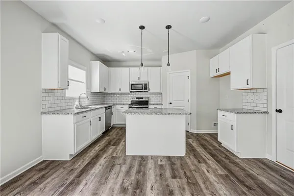 a kitchen with granite countertop white cabinets and white appliances