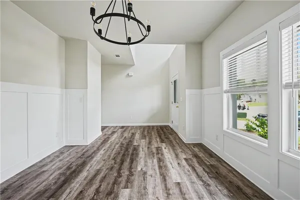 a view of a room with wooden floor fan and windows