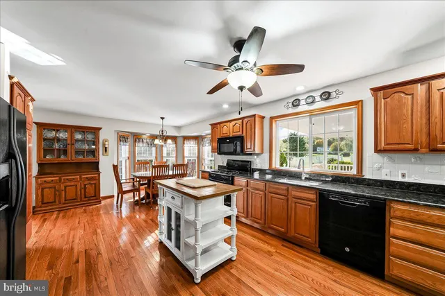 a living room with stainless steel appliances furniture a fireplace and a flat screen tv