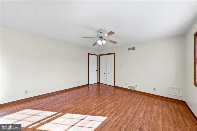 an empty room with a window and a ceiling fan