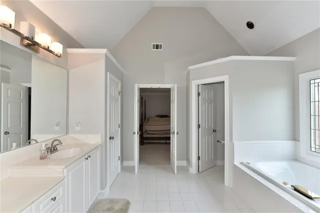 a bathroom with a tub sink and mirror