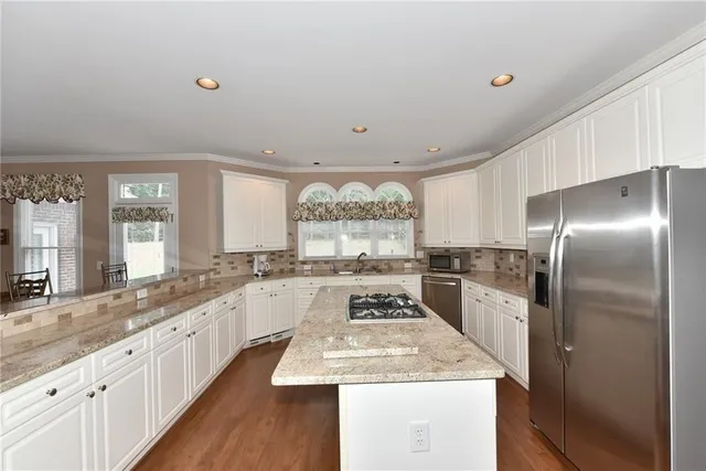 a large kitchen with a large window and stainless steel appliances