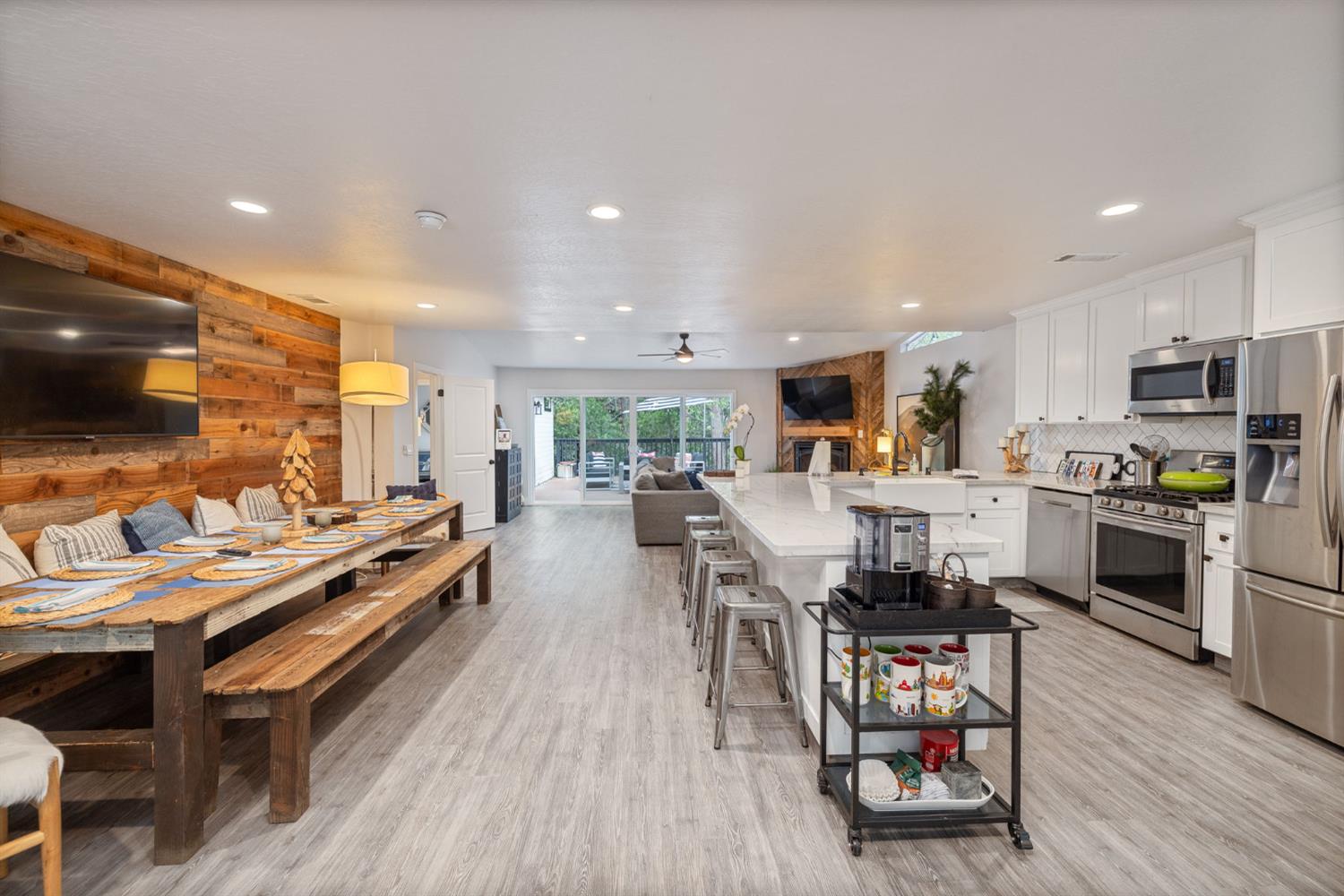 39253 Robin Bass Lake, CA 93604 - Photo 12 of 86 a open kitchen with stainless steel appliances kitchen island granite countertop a stove top oven a sink a dining table and chairs with wooden floor