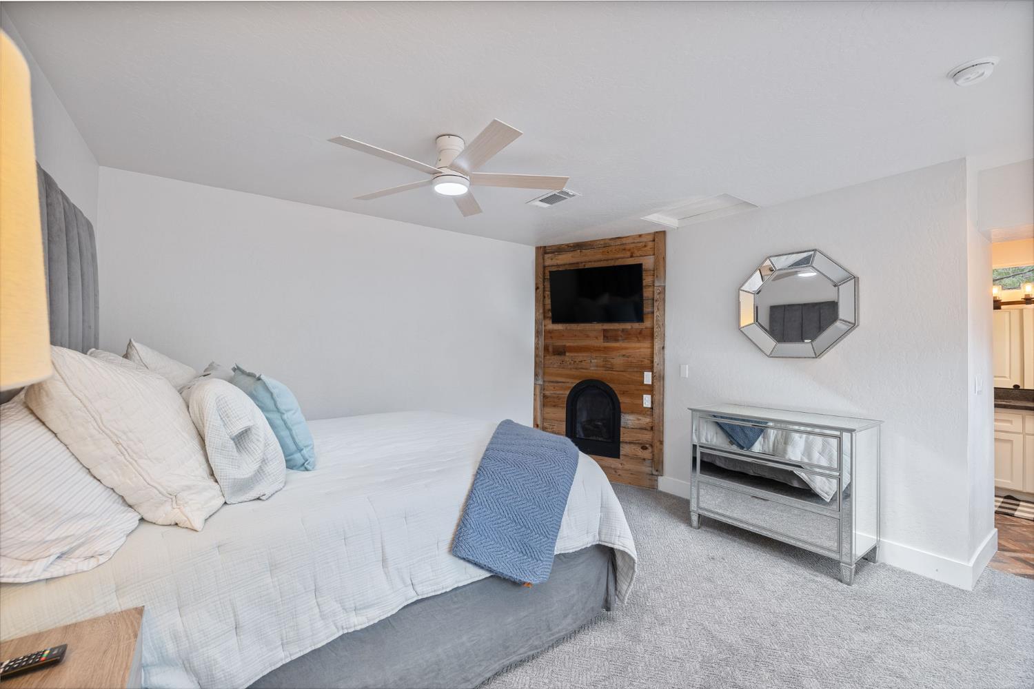 39253 Robin Bass Lake, CA 93604 - Photo 22 of 86 a spacious bedroom with a bed a fireplace and a chandelier