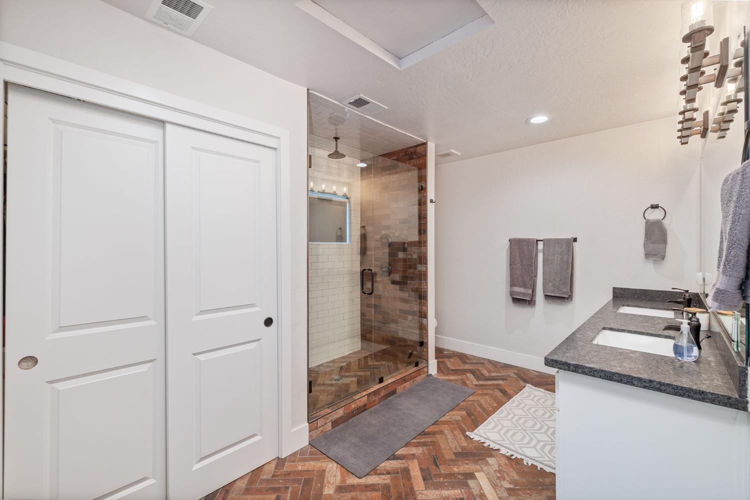 39253 Robin Bass Lake, CA 93604 - Photo 48 of 86 a spacious bathroom with a granite countertop sink a mirror and shower