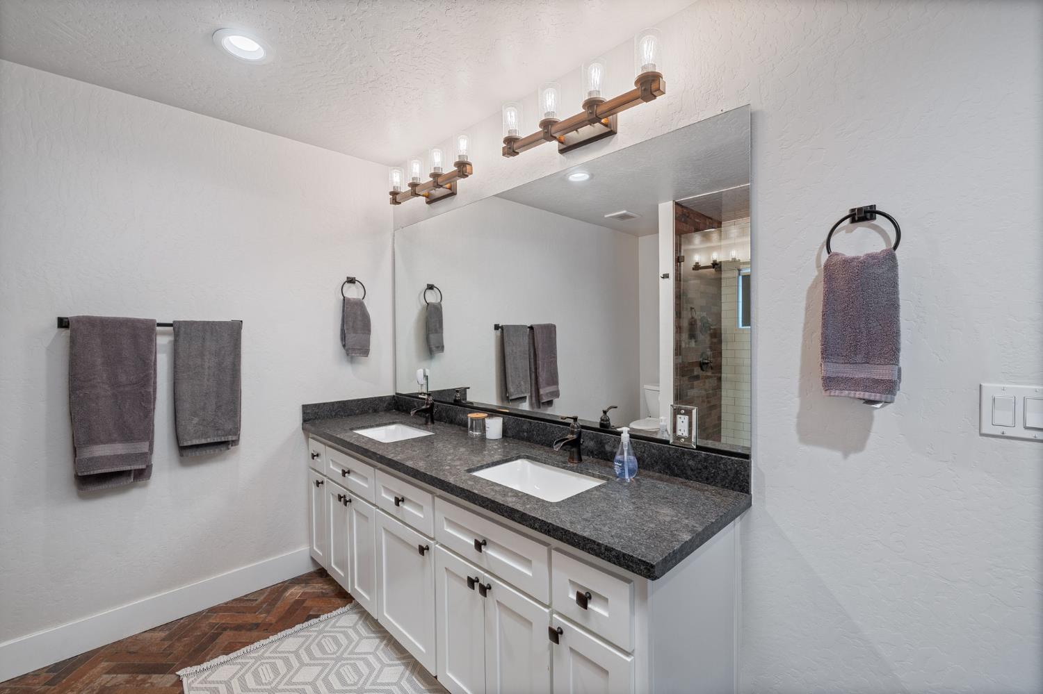 39253 Robin Bass Lake, CA 93604 - Photo 49 of 86 a bathroom with a granite countertop sink and a mirror