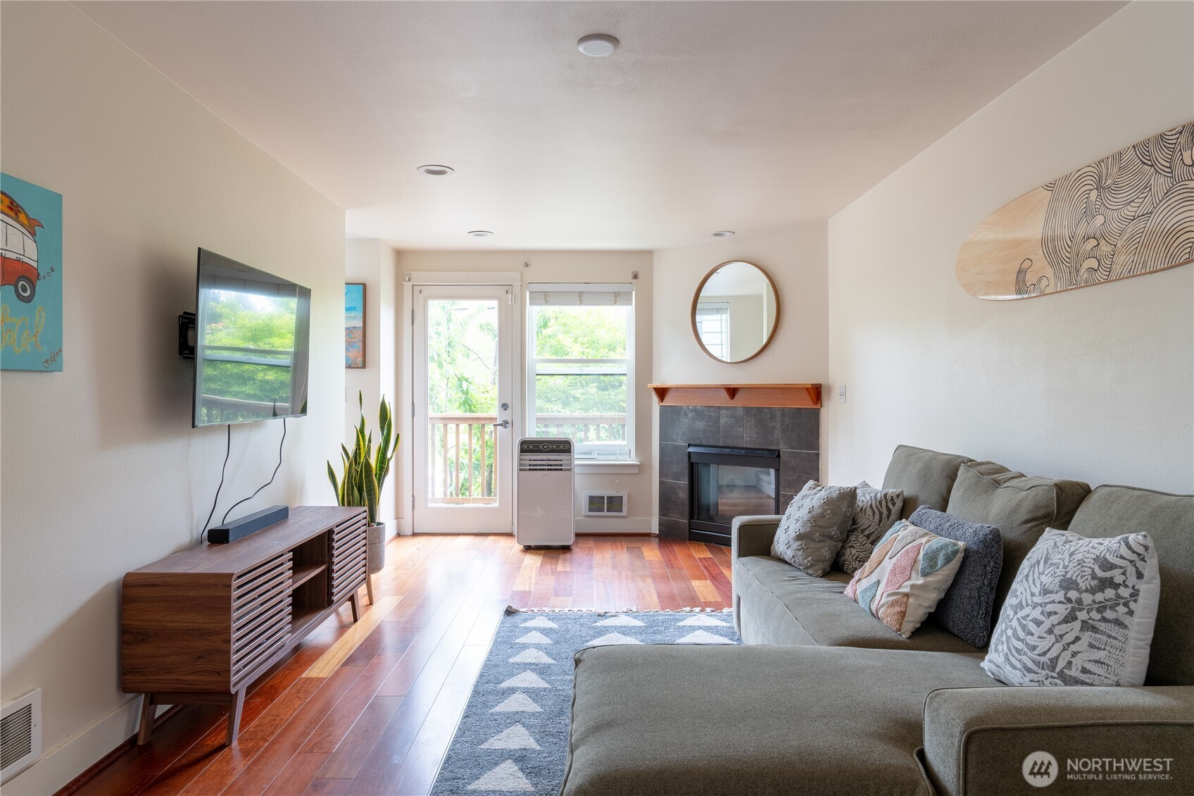 1419 Northwest 65th Street, Unit B Seattle, WA 98117 - Photo 3 of 26 a living room with furniture a fireplace and a flat screen tv