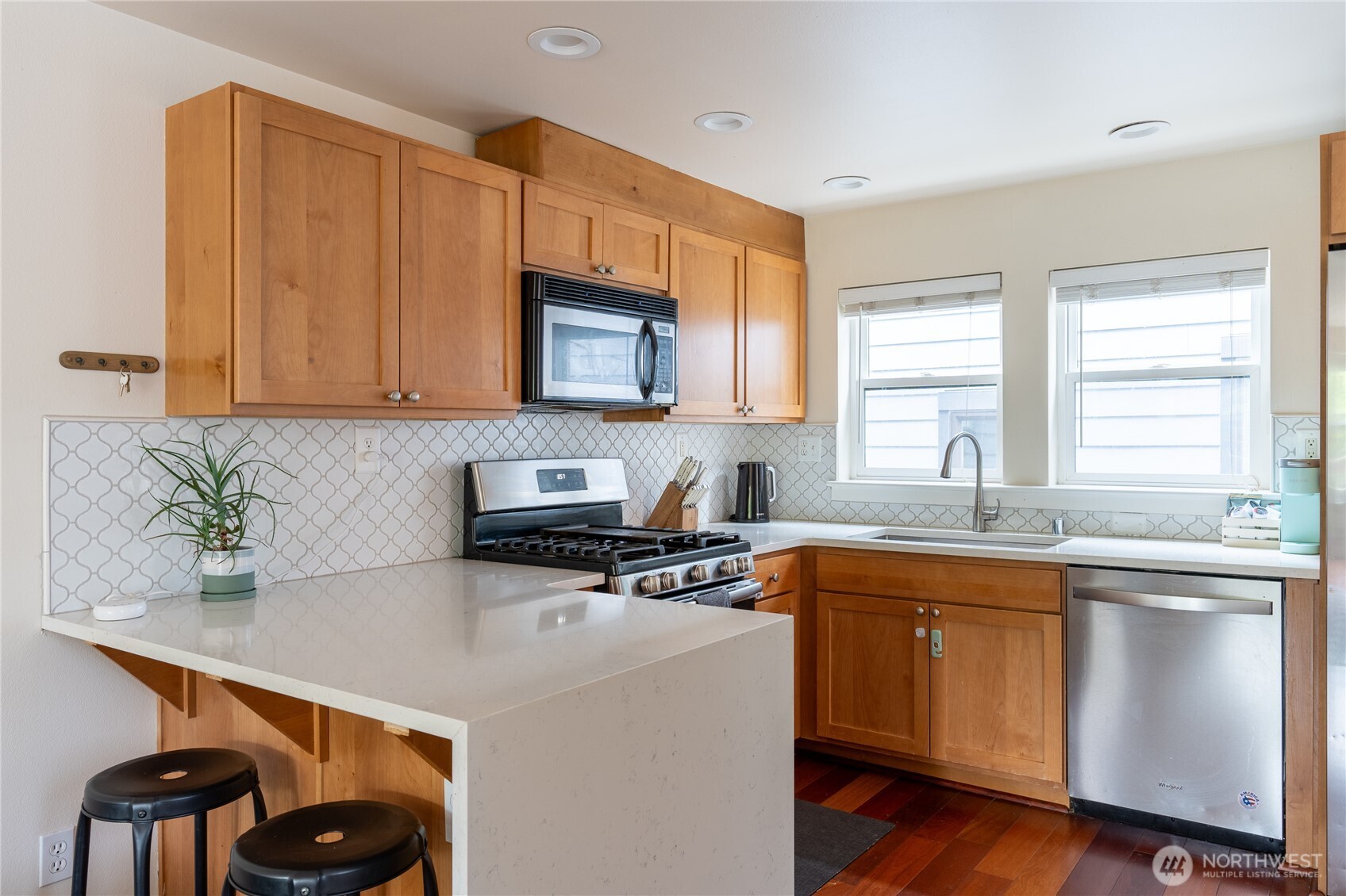 1419 Northwest 65th Street, Unit B Seattle, WA 98117 - Photo 4 of 26 a kitchen with stainless steel appliances a sink a stove a microwave a sink a refrigerator and wooden cabinets