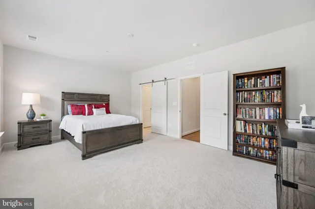 a spacious bedroom with a bed and wooden floor