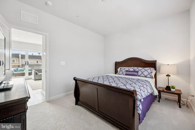 a bedroom with a bed a table and windows