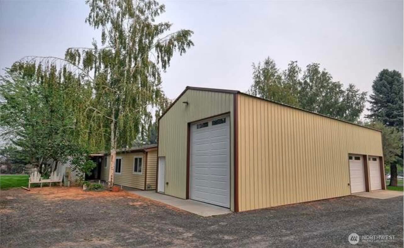 7472 Rd F Southeast, Unit 8 Othello, WA 99344 - Photo 34 of 40 a backyard of a house with large trees and brick wall