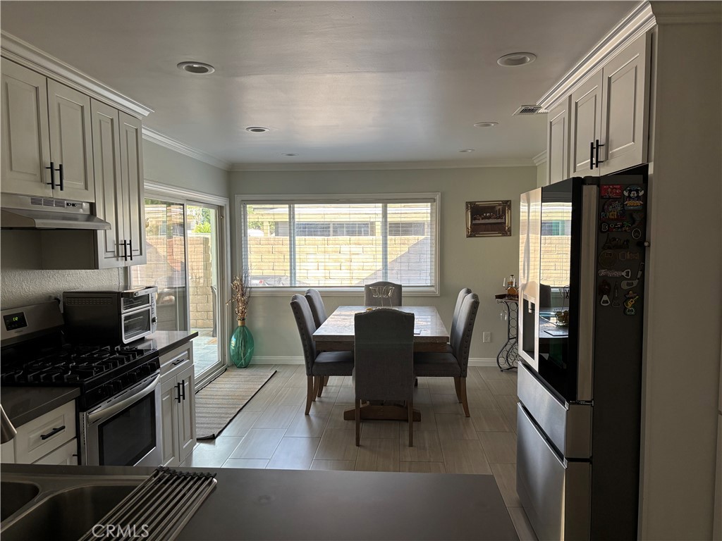 6450 Arthur Street Chino, CA 91710 - Photo 4 of 16 a kitchen with stainless steel appliances granite countertop a stove a refrigerator a kitchen island a table and chairs