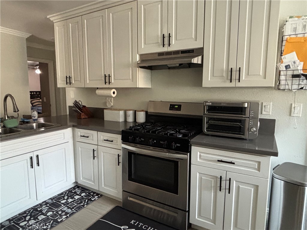 6450 Arthur Street Chino, CA 91710 - Photo 5 of 16 a kitchen with granite countertop white cabinets and stainless steel appliances