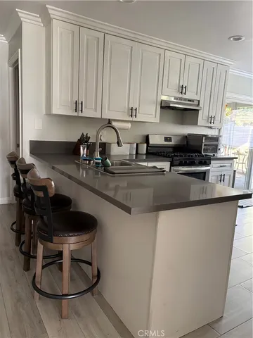 a kitchen with stainless steel appliances granite countertop a sink a stove a microwave and cabinets