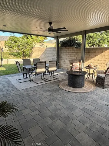 a view of a patio with table and chairs potted plants with floor to ceiling window