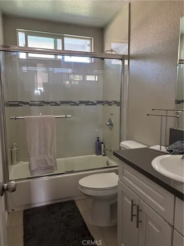 a bathroom with a granite countertop sink mirror vanity and toilet