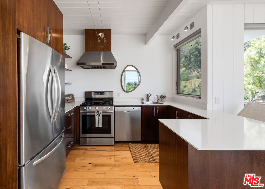 3431 Coast View Drive Malibu, CA 90265 - Photo 43 of 49 a kitchen with stainless steel appliances granite countertop a refrigerator a stove and a sink