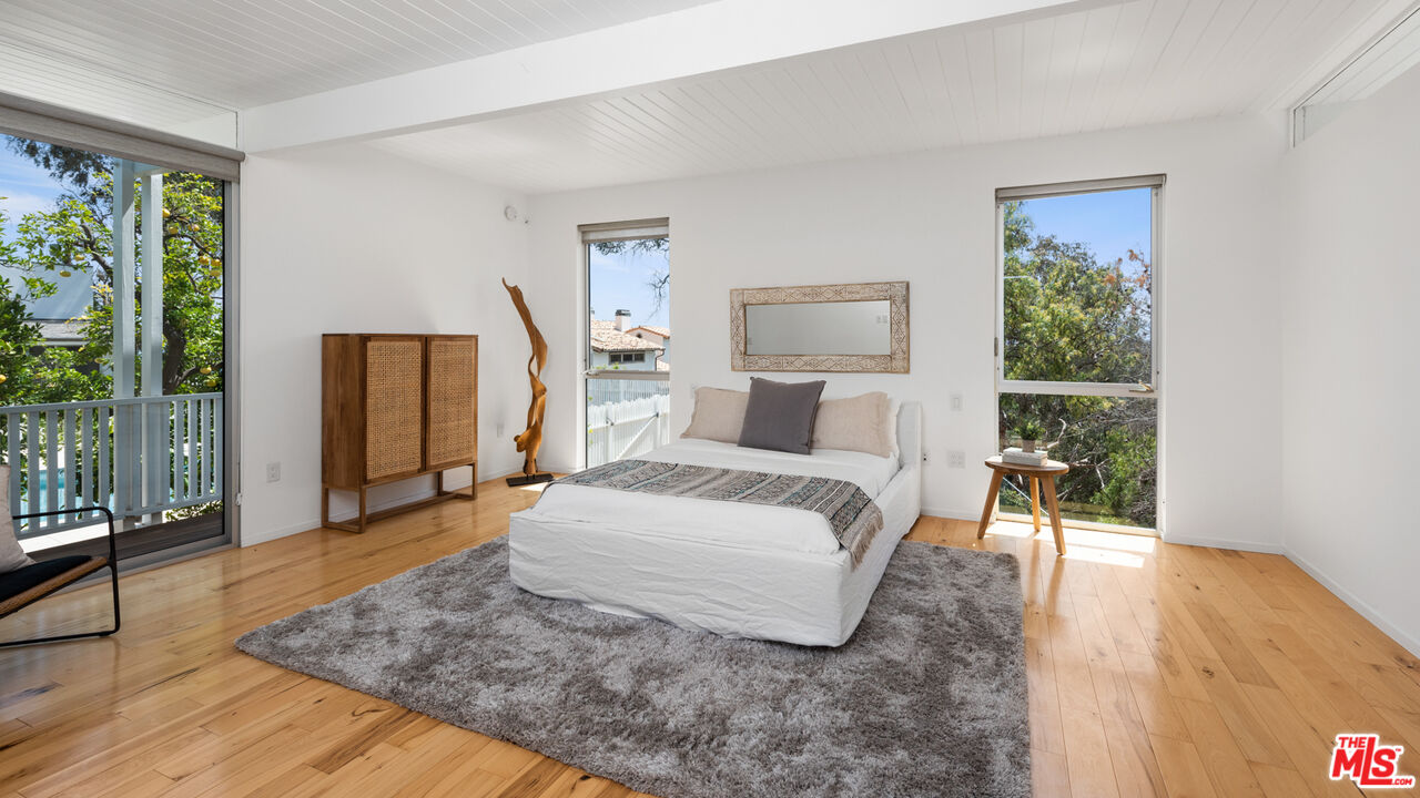 3431 Coast View Drive Malibu, CA 90265 - Photo 45 of 49 a bedroom with a large bed and a wooden floor